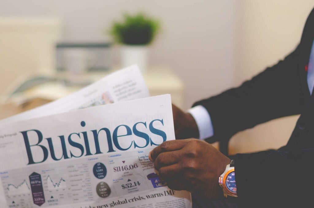 man's hands holding business newspaper